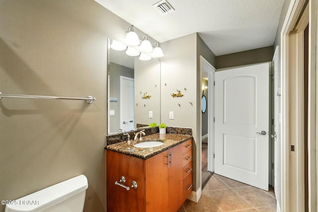 2515 S Atlantic Ave Unit 502, Daytona Beach, FL 32118 - half bath featuring vanity, toilet, tile patterned flooring, and a textured ceiling