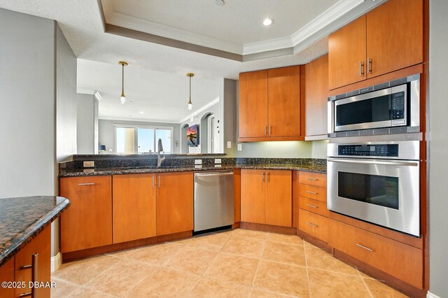 2515 S Atlantic Ave Unit 502, Daytona Beach, FL 32118 - kitchen featuring stainless steel appliances, ornamental molding, a sink, brown cabinets, and a raised ceiling