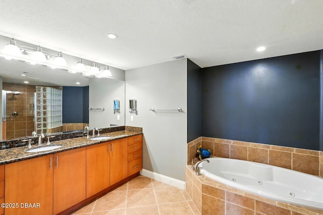 2515 S Atlantic Ave Unit 502, Daytona Beach, FL 32118 - bathroom featuring double vanity, a tub with jets, tile patterned flooring, a stall shower, and baseboards