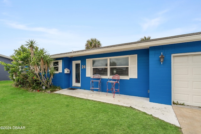 ranch-style house featuring a front lawn and a garage