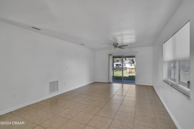 spare room with ceiling fan and light tile patterned floors