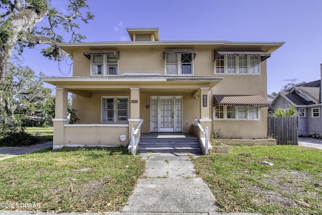 view of front facade featuring fence, covered porch, and stucco siding