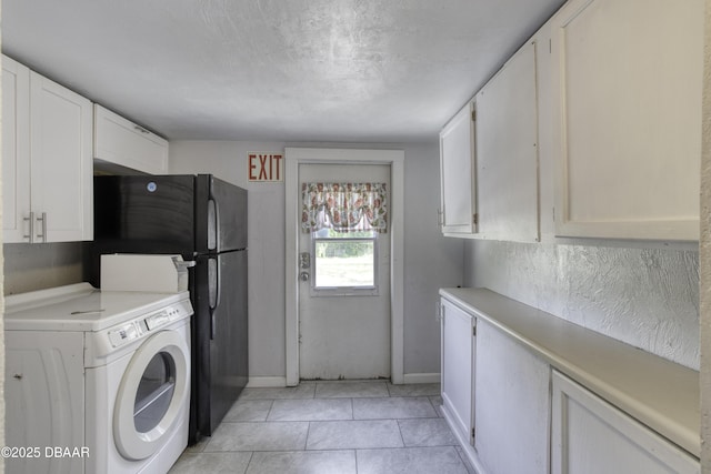 washroom with washer / clothes dryer, light tile patterned flooring, baseboards, and cabinet space