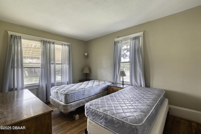 bedroom with dark wood-style flooring and baseboards