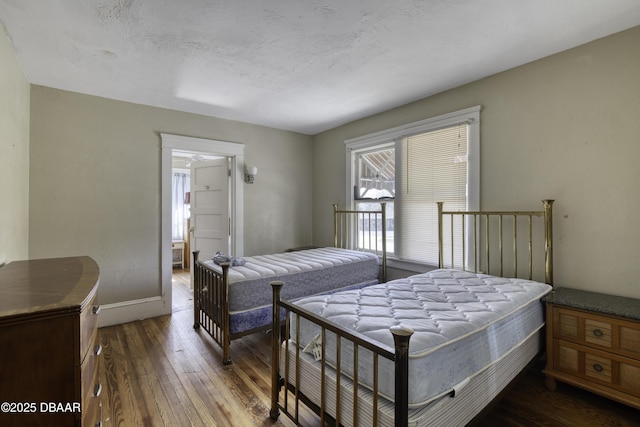 bedroom featuring baseboards and hardwood / wood-style floors