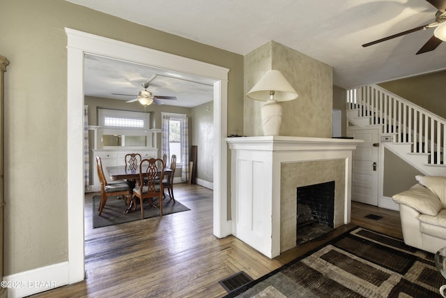 living area with visible vents, baseboards, ceiling fan, and wood finished floors