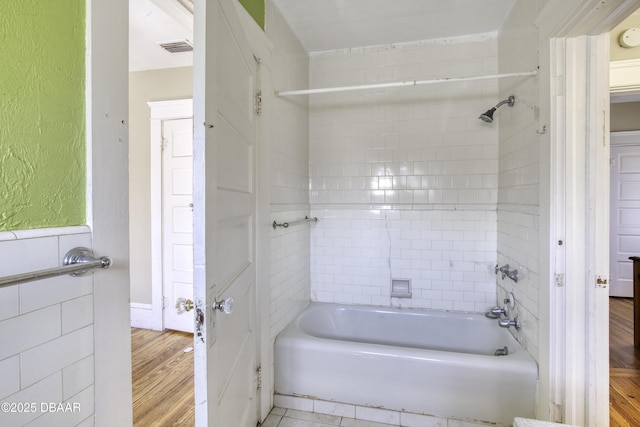 full bathroom featuring visible vents, shower / tub combination, and wood finished floors