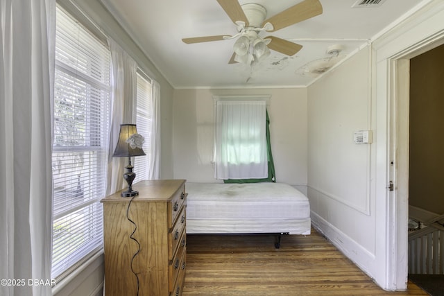 bedroom featuring crown molding, a ceiling fan, dark wood finished floors, and visible vents
