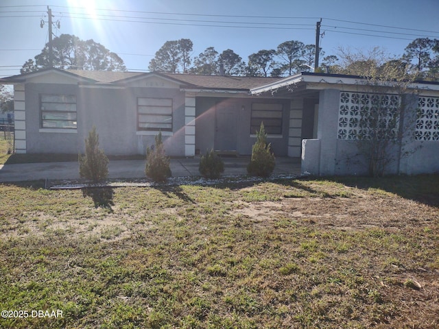 view of front of home with stucco siding and a front lawn