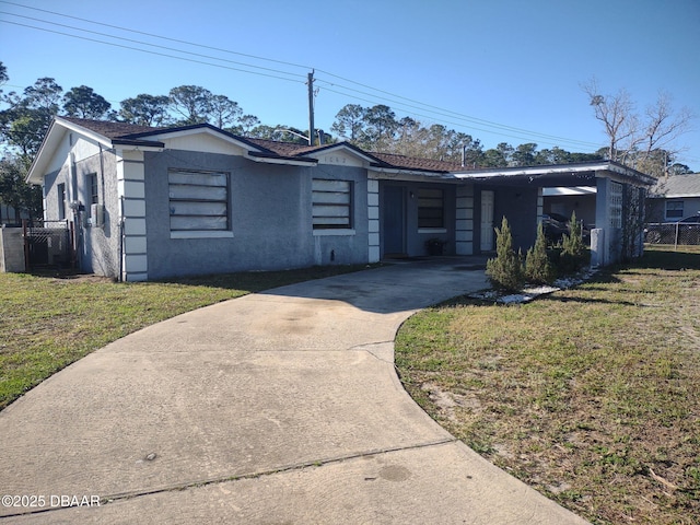 view of front of property featuring stucco siding, driveway, a front yard, and fence