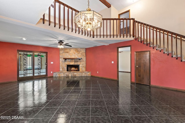 7 Appaloosa Trl, Ormond Beach, FL 32174 - unfurnished living room featuring a high ceiling, a chandelier, ceiling fan, a stone fireplace, and baseboards