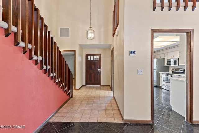 7 Appaloosa Trl, Ormond Beach, FL 32174 - tiled foyer entrance with baseboards, a towering ceiling, and stairway
