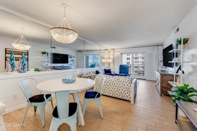 dining area with a notable chandelier and light hardwood / wood-style flooring