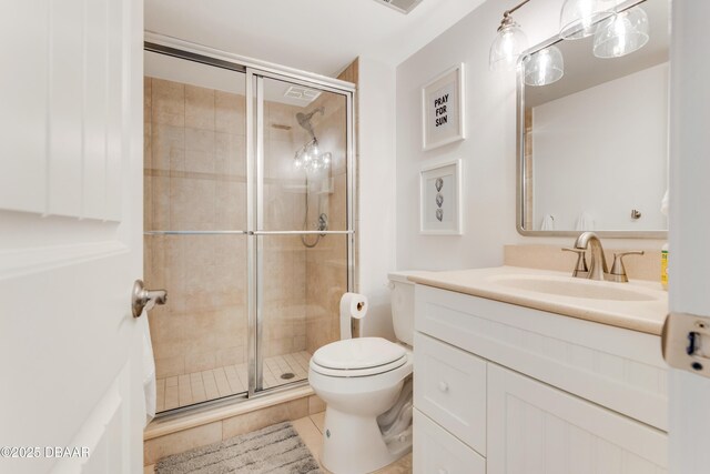 bathroom with tile patterned flooring, vanity, toilet, and a shower with shower door