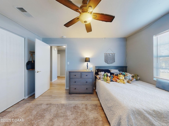 bedroom featuring ceiling fan, light hardwood / wood-style floors, and a closet