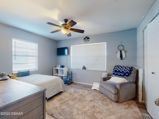 bedroom featuring ceiling fan, a closet, and light hardwood / wood-style flooring