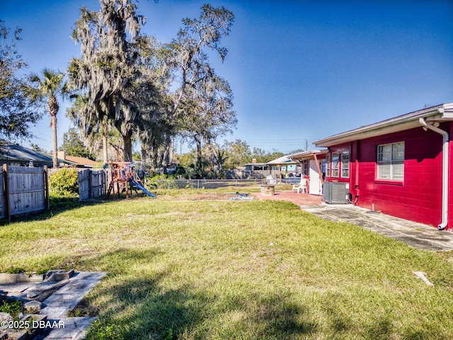 view of yard featuring a playground and central air condition unit