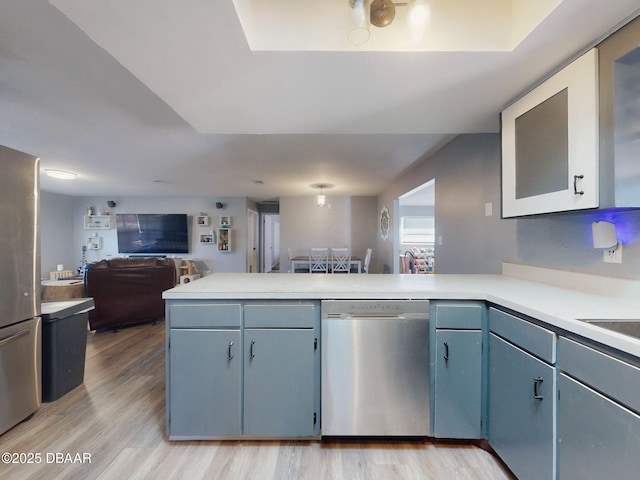 kitchen with kitchen peninsula, light hardwood / wood-style floors, and stainless steel dishwasher