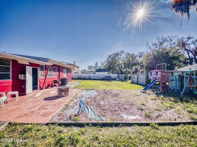 view of yard featuring a playground, a patio area, an outdoor fire pit, and central air condition unit