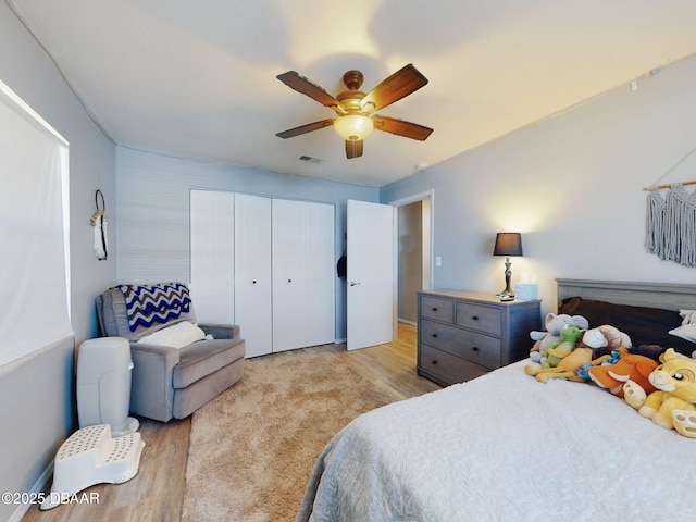 bedroom featuring ceiling fan, light hardwood / wood-style floors, and a closet