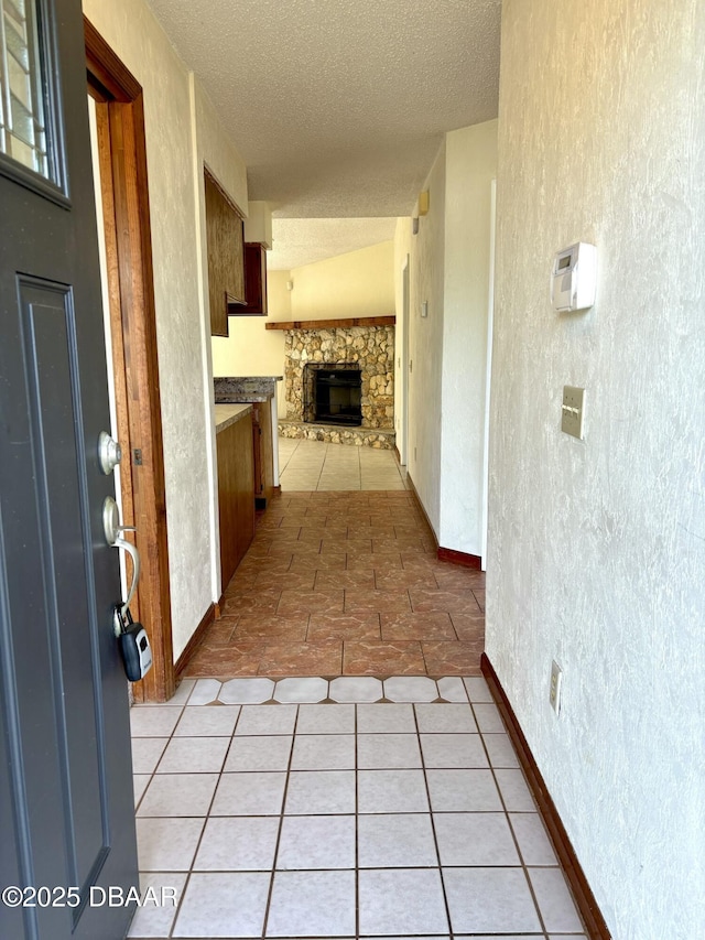 156 Riverwalk Ct, Ormond Beach, FL 32176 - corridor with light tile patterned flooring, a textured ceiling, and baseboards