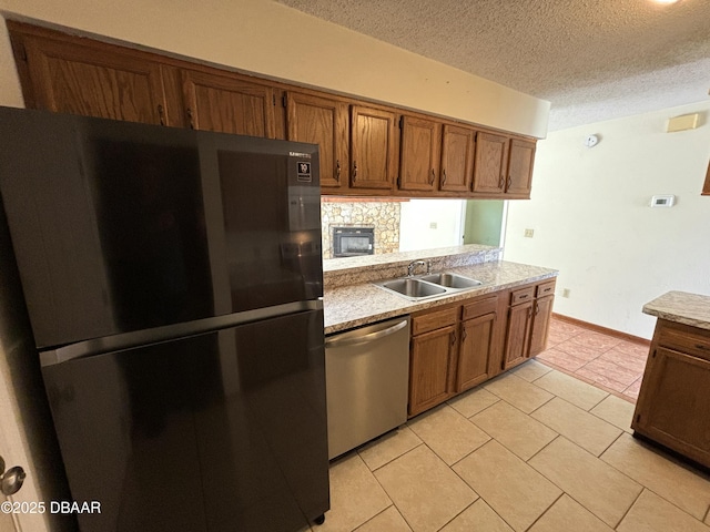 156 Riverwalk Ct, Ormond Beach, FL 32176 - kitchen featuring light countertops, stainless steel dishwasher, a sink, freestanding refrigerator, and brown cabinets