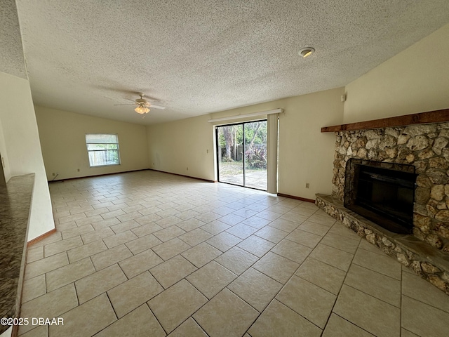 unfurnished living room featuring light tile patterned floors, ceiling fan, plenty of natural light, and a fireplace