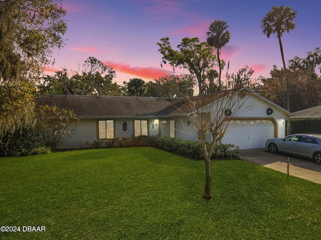 ranch-style house featuring a lawn and a garage