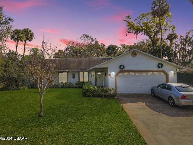 ranch-style house featuring a lawn and a garage