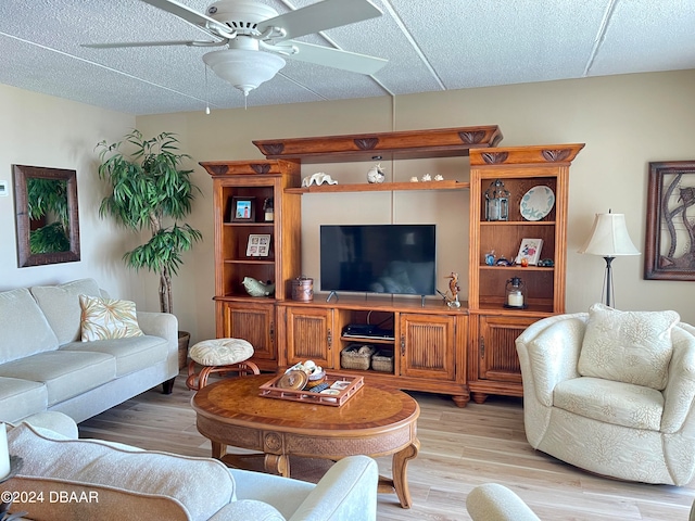 living room with ceiling fan, a textured ceiling, and light hardwood / wood-style floors