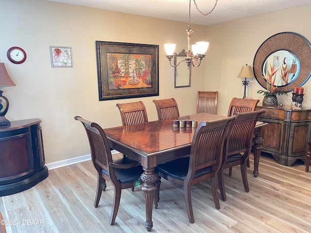 dining room featuring a chandelier, a textured ceiling, and light hardwood / wood-style flooring