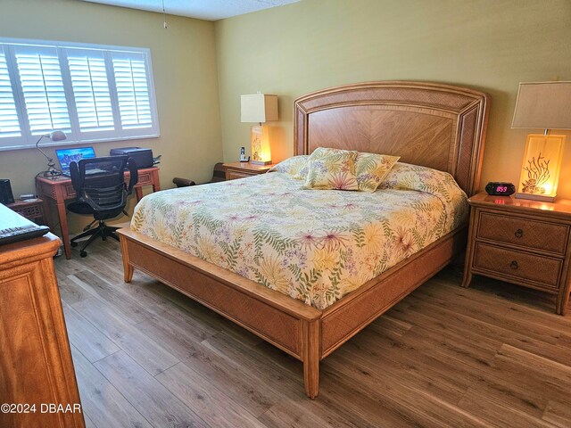 bedroom with dark hardwood / wood-style floors