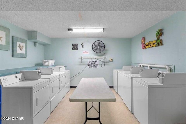 clothes washing area with washer and dryer and a textured ceiling