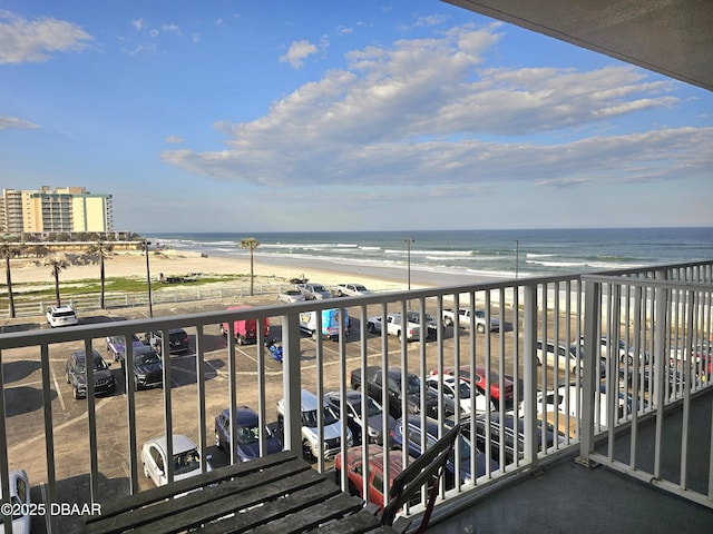 balcony featuring a water view and a beach view