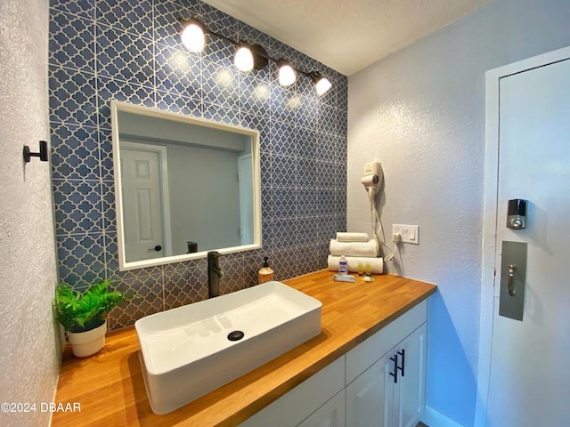 bathroom with hardwood / wood-style flooring, vanity, and backsplash