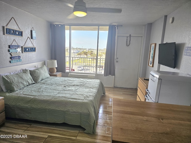 bedroom featuring ceiling fan, access to outside, and a textured ceiling