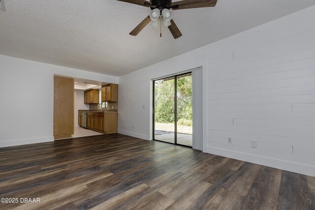 252 Manhattan Way, Port Orange, FL 32129 - unfurnished living room with dark wood-style flooring, a ceiling fan, a textured ceiling, and baseboards