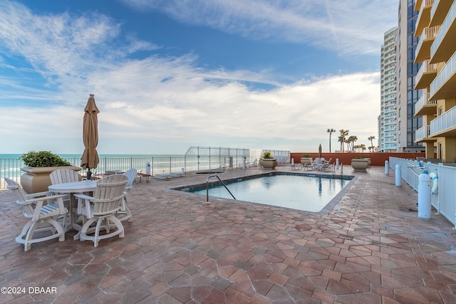 view of swimming pool featuring a patio area and a water view