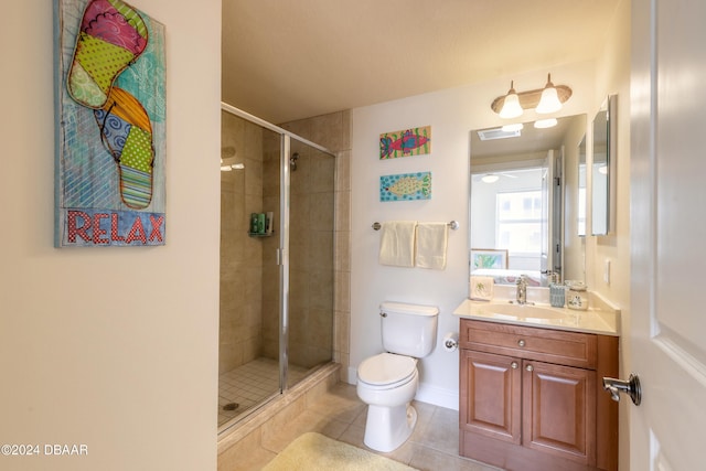 bathroom with vanity, a shower with door, tile patterned floors, and toilet