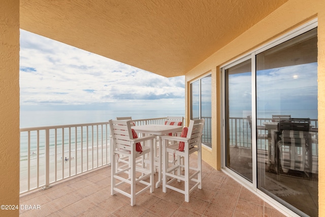 balcony featuring a water view and a view of the beach