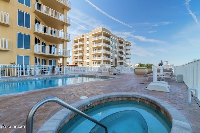 view of swimming pool featuring a community hot tub and a patio