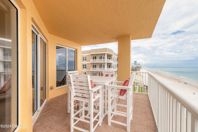 balcony featuring a beach view and a water view