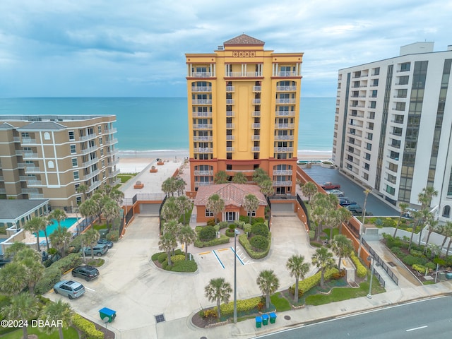 view of property with a water view and a view of the beach