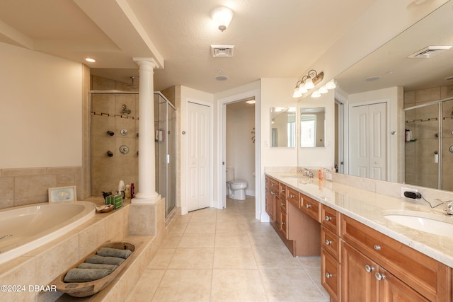 full bathroom with toilet, tile patterned flooring, plus walk in shower, decorative columns, and vanity