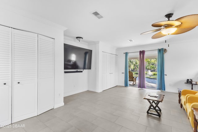 unfurnished living room with ceiling fan and crown molding