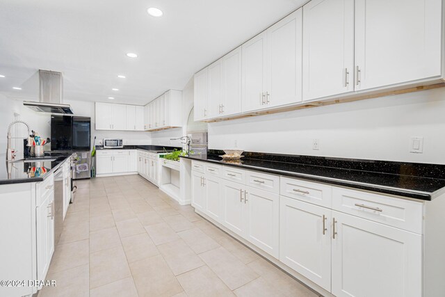 1870 S Air Park Rd, Edgewater, FL 32141 - kitchen featuring recessed lighting, light tile patterned floors, white cabinets, and island range hood