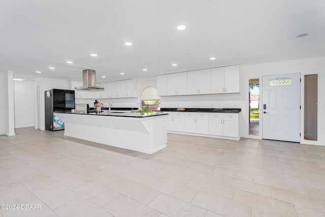 1870 S Air Park Rd, Edgewater, FL 32141 - kitchen featuring wall chimney exhaust hood, fridge, dark countertops, white cabinetry, and recessed lighting