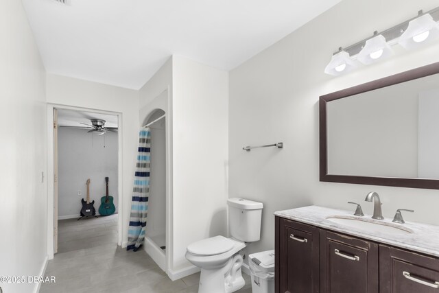 bathroom featuring a shower with shower curtain, ceiling fan, toilet, and vanity