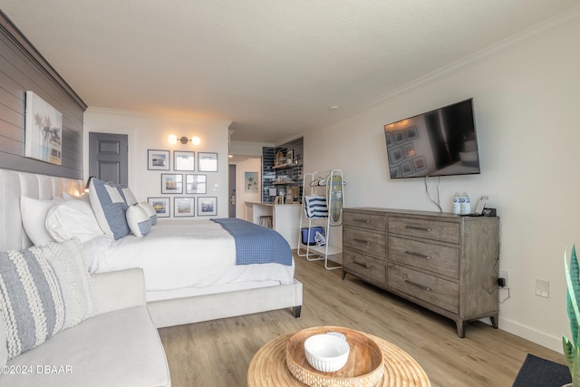bedroom featuring light wood-type flooring and crown molding