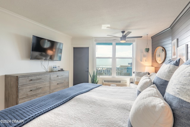 bedroom featuring a wall mounted AC, a textured ceiling, ceiling fan, and crown molding